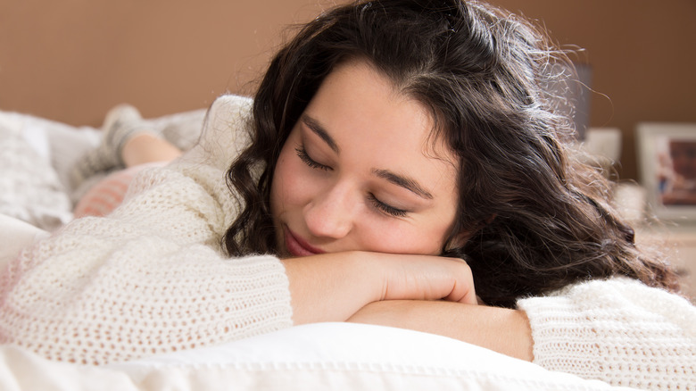 A woman napping in bed because of daylight savings time