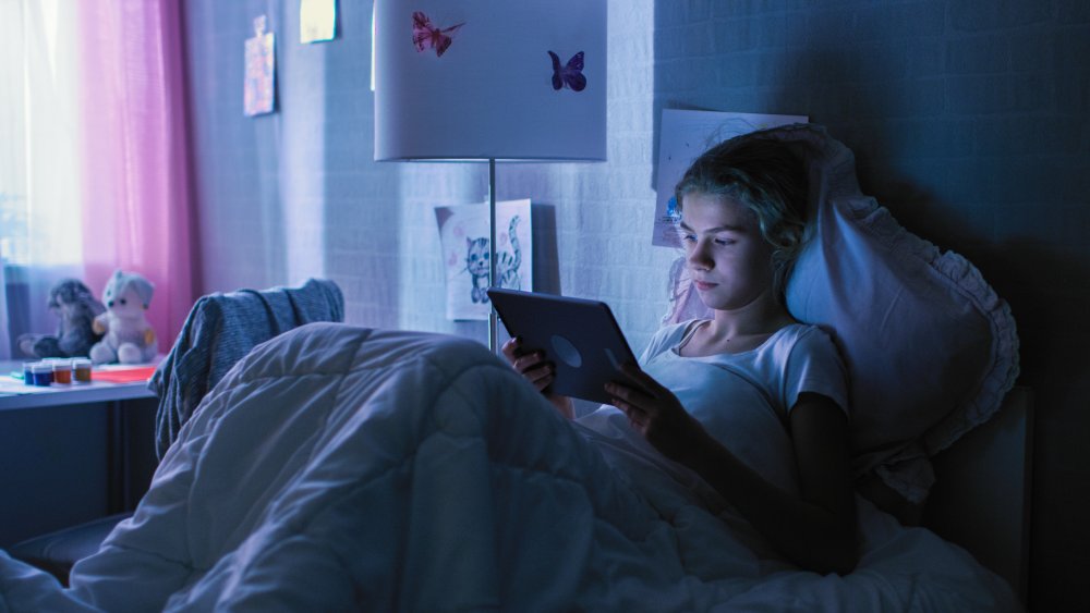 woman binge-watching Netflix in bed