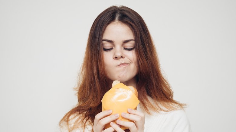 woman contemplating eating burger