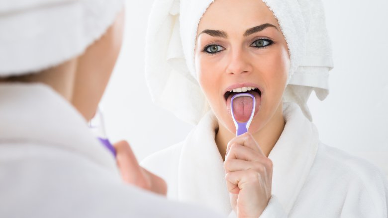 woman using tongue scraper