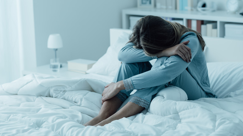 woman crying on bed