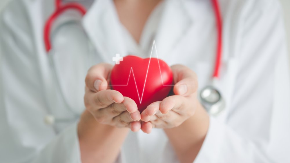 A doctor holding a heart in her hands