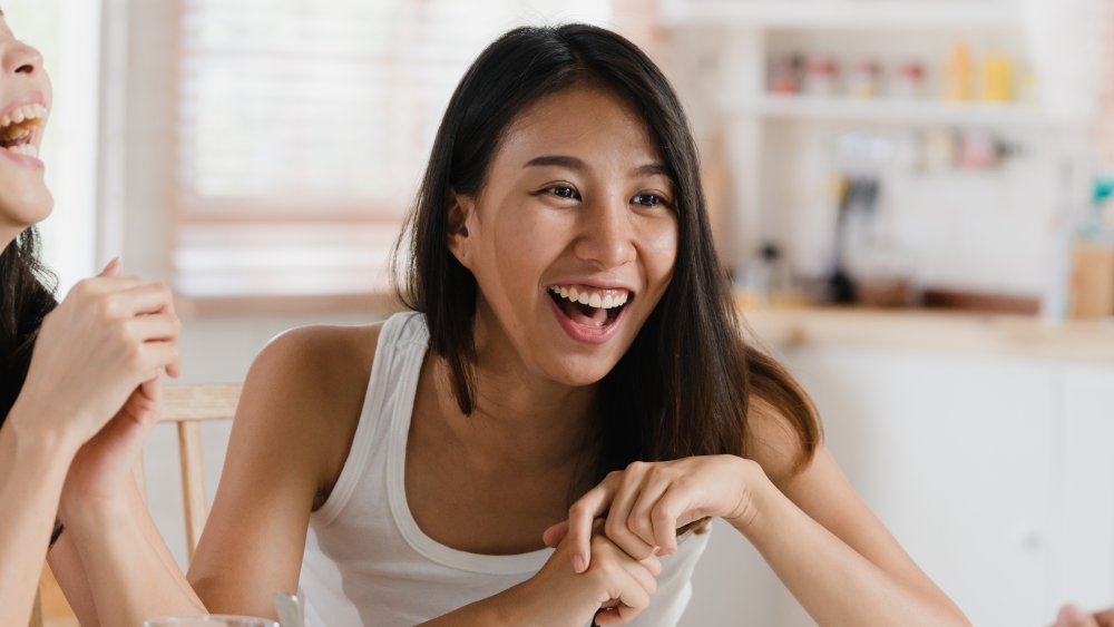 Women eating breakfast together, laughing