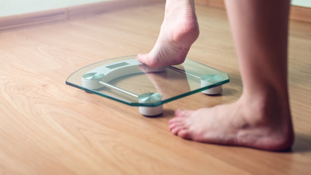 A woman's feet stepping onto a scale