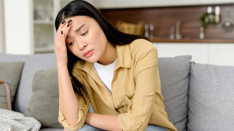 woman in pain touching head