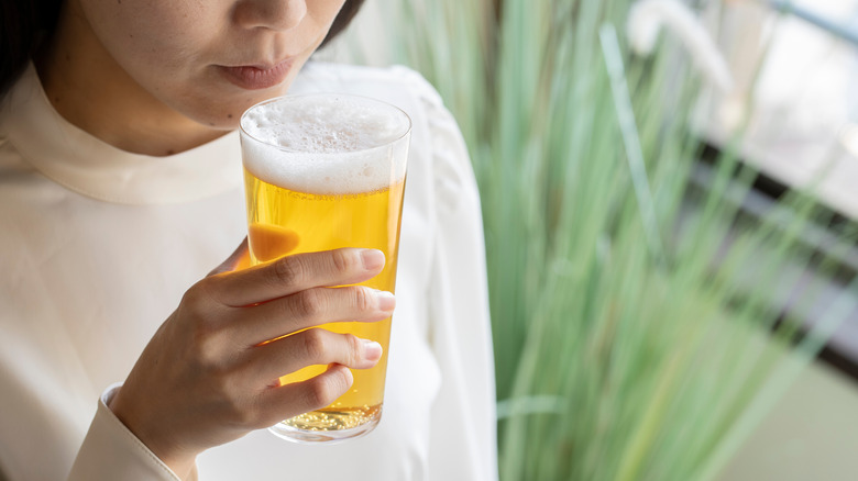 Woman drinking beer at bar