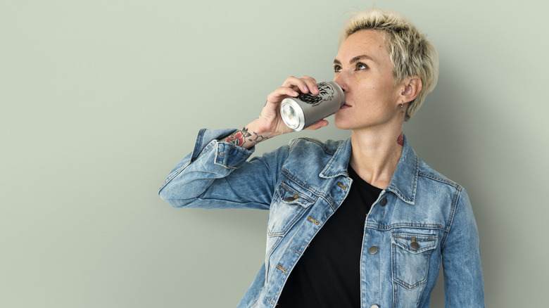 Woman sipping beer from can