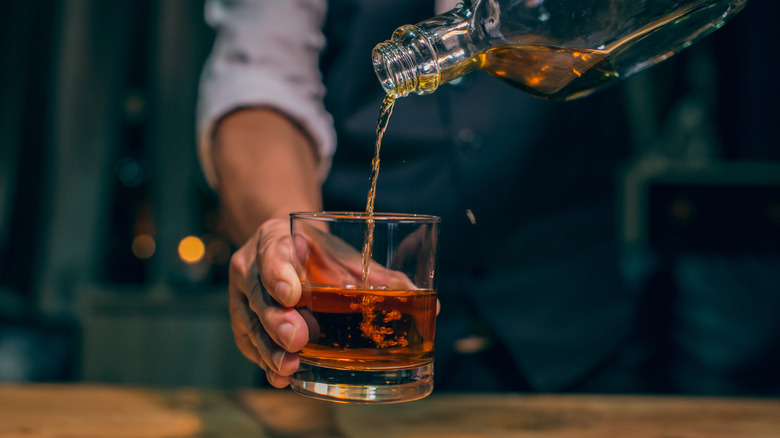 man pouring whiskey into a glass