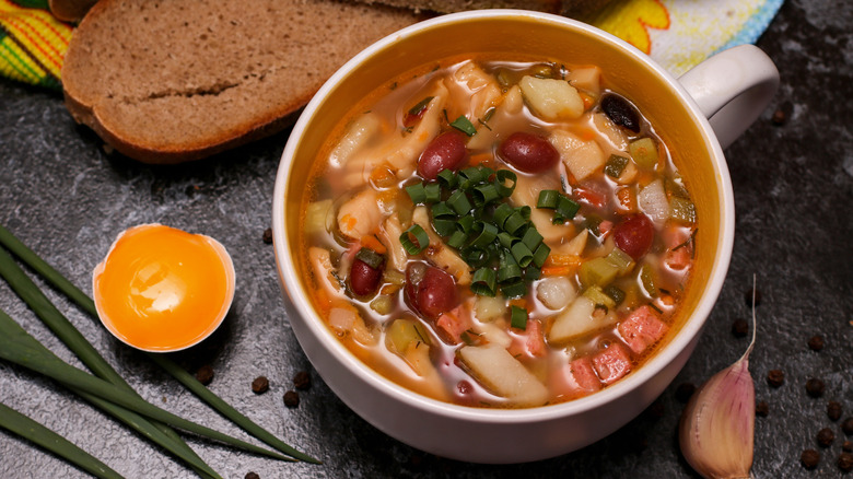 Bean soup in a bowl with toast, egg, and garlic