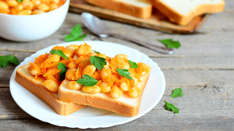 A plate of baked beans on toast with cilantro