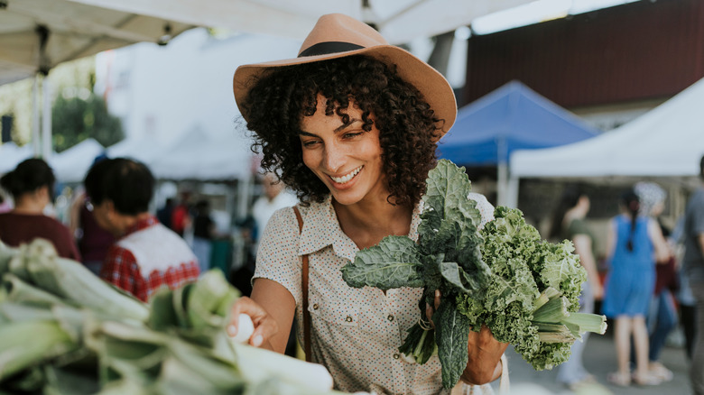 A woman buying kale at a market