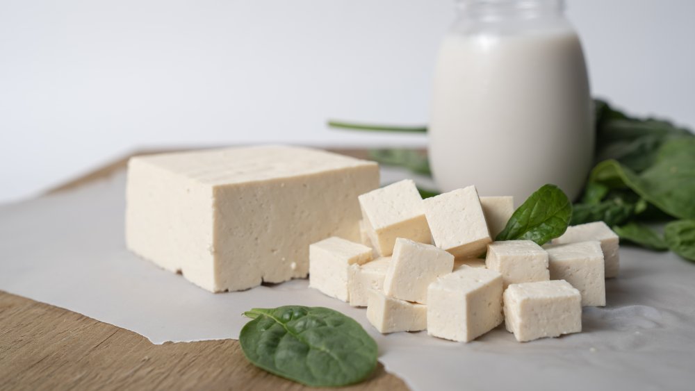 Tofu on a table with milk and basil