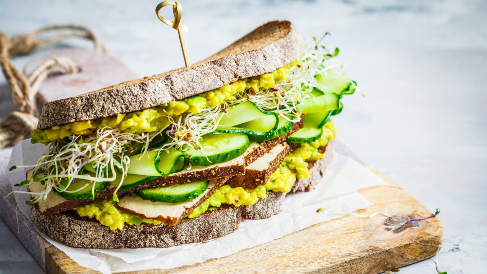 A tofu sandwich with vegetables on wheat