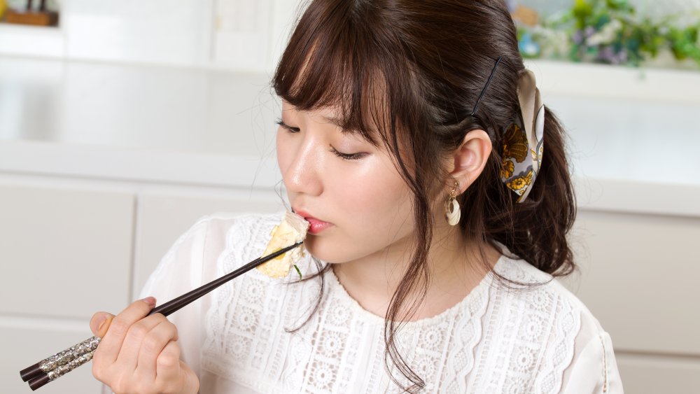 A woman eating tofu