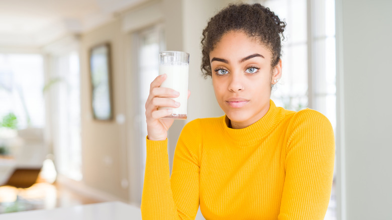 Woman holding up glass of milk