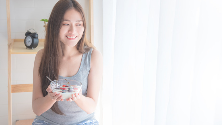 Woman holding bowl of yogurt