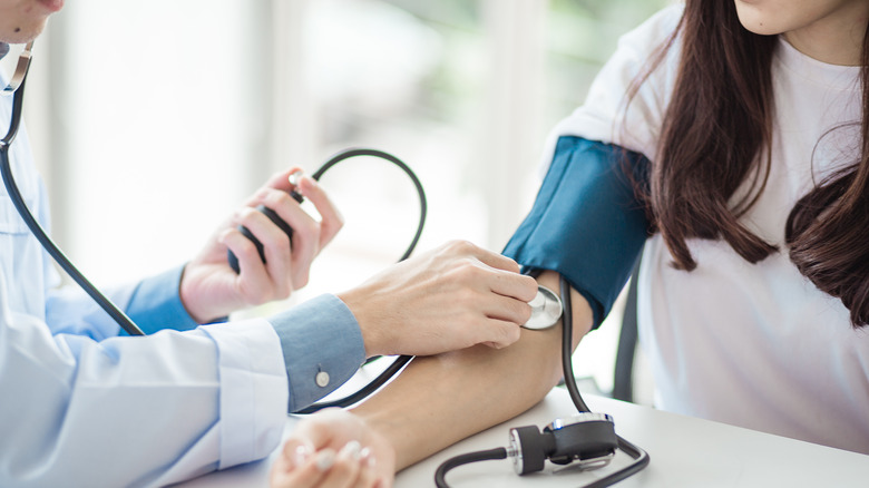 doctor taking patient's blood pressure