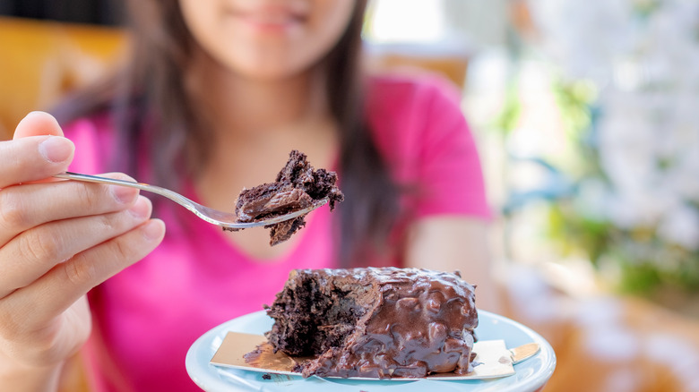 A woman eating cake and ingesting too much sugar