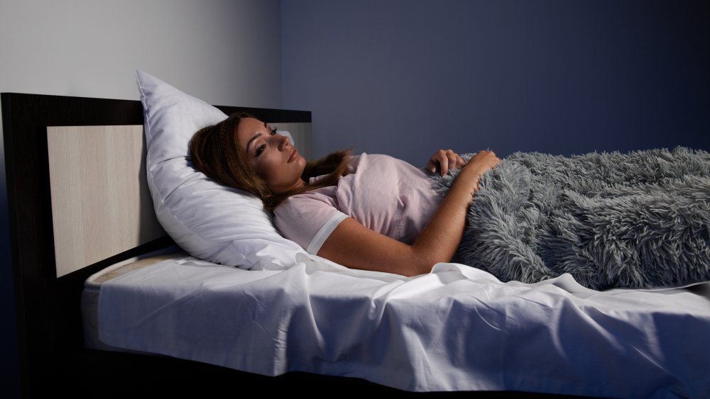 A woman awake in bed at night