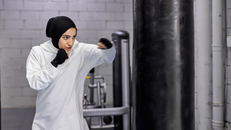 A woman punches a bag