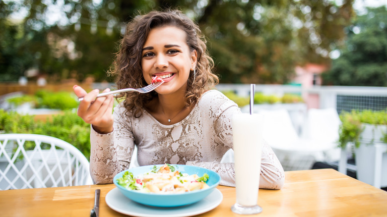 A content woman eating a salad