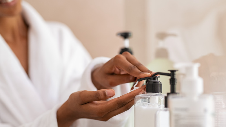 Woman pumps lotion bottle