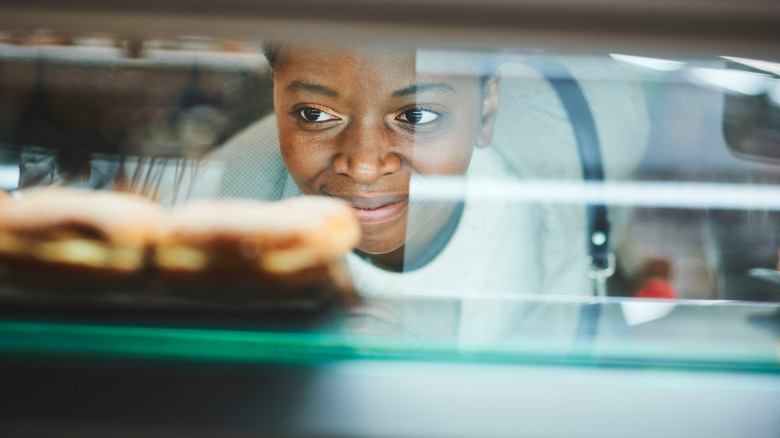 woman eyeing baked goods display