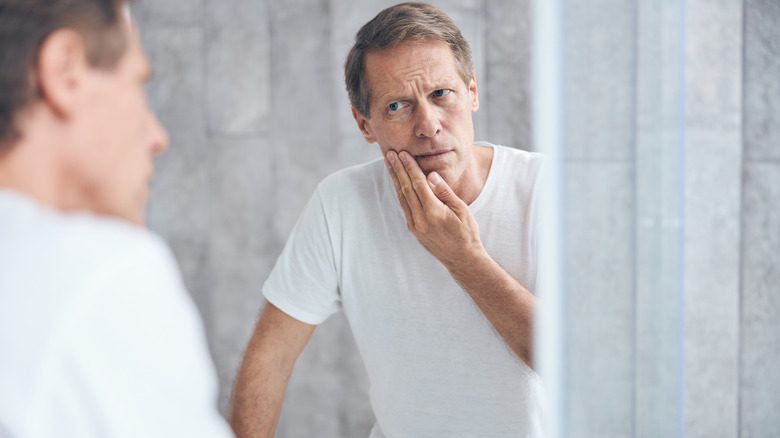 Man examines his reflection