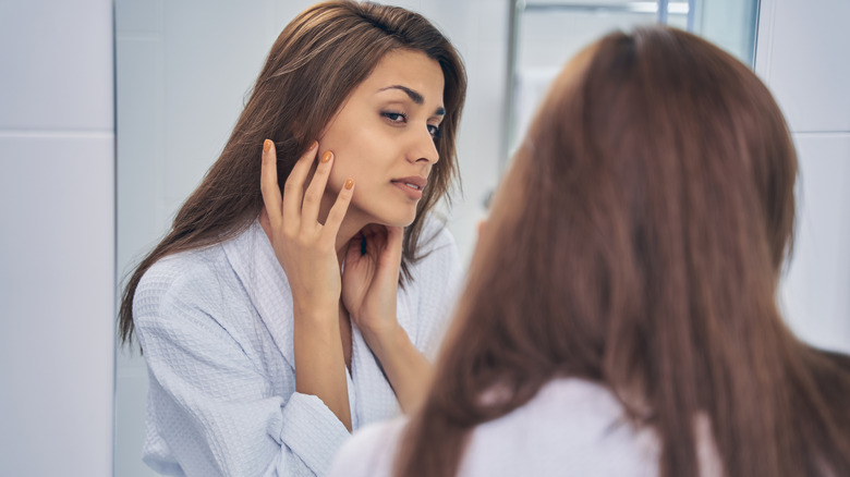 Woman looks at reflection