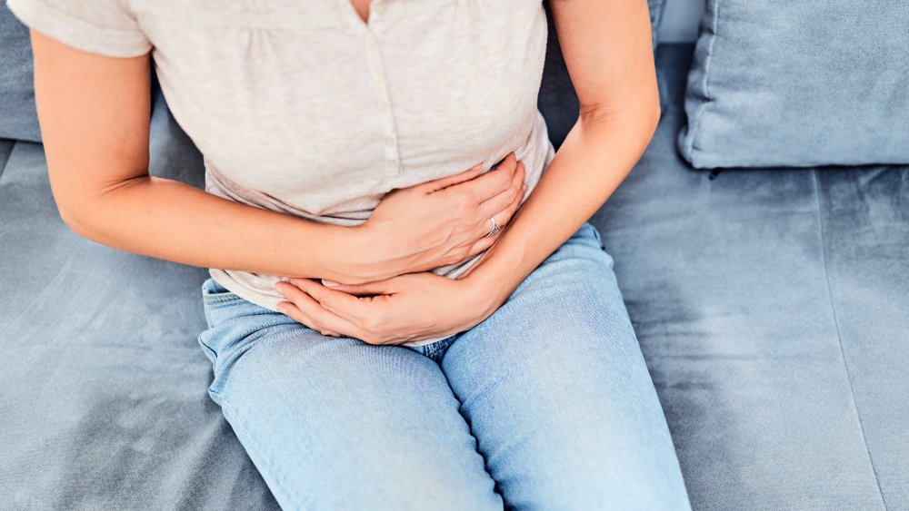 Woman holding stomach.