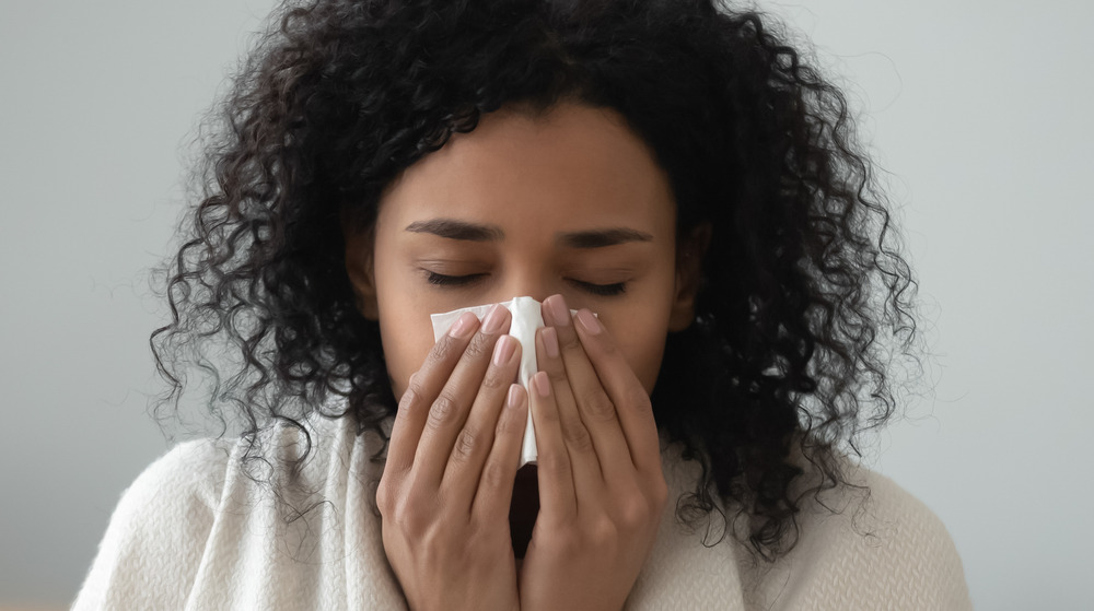 A woman blowing her nose