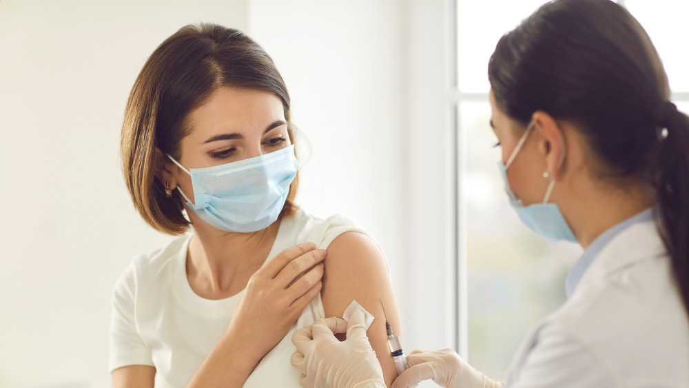 A woman getting vaccinated by her doctor