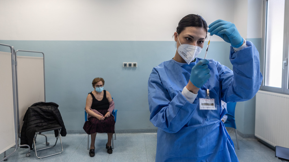 woman administering COVID-19 vaccine 