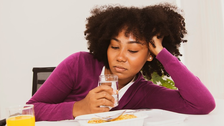 Woman looking at plate of food