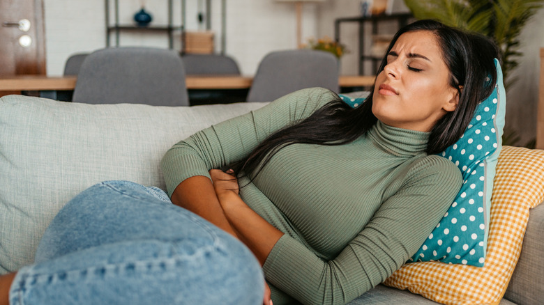 Woman lying down with hands on stomach