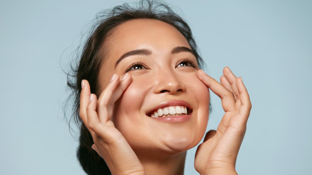 A woman touching her cheeks