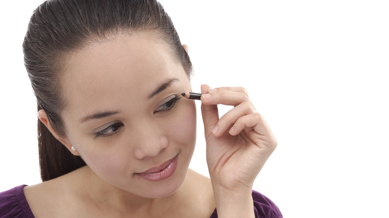 Woman applying eyeliner