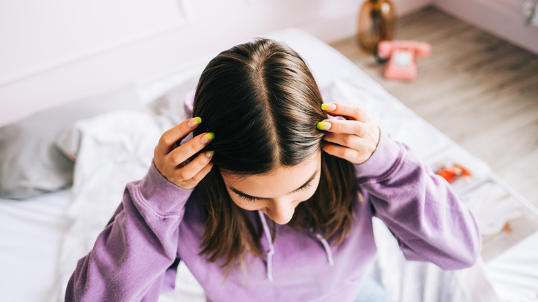 Woman parting hair in center