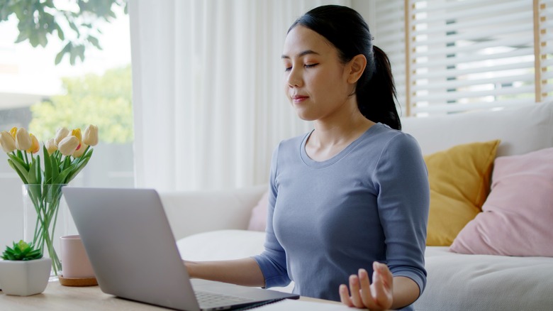 woman deep breathing while at home working