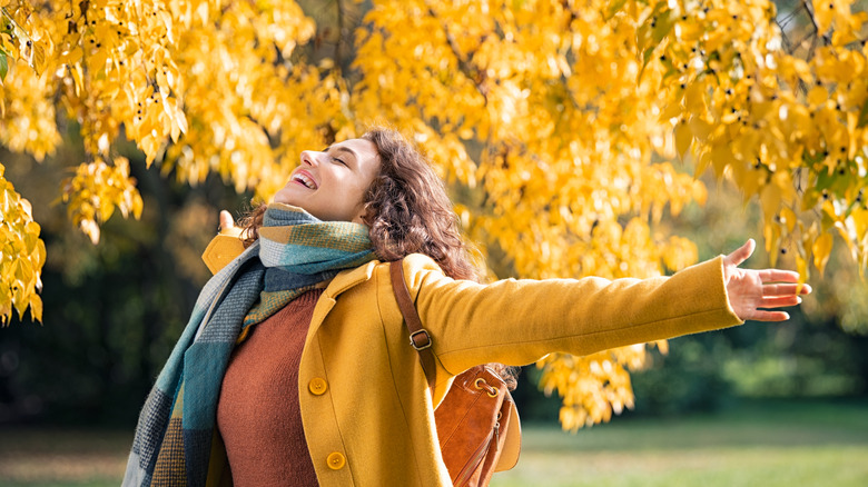 Happy woman in autumn leaves