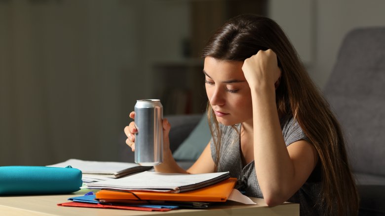 Woman studying and drinking energy drink