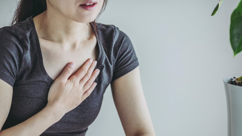 woman holding hand over heart