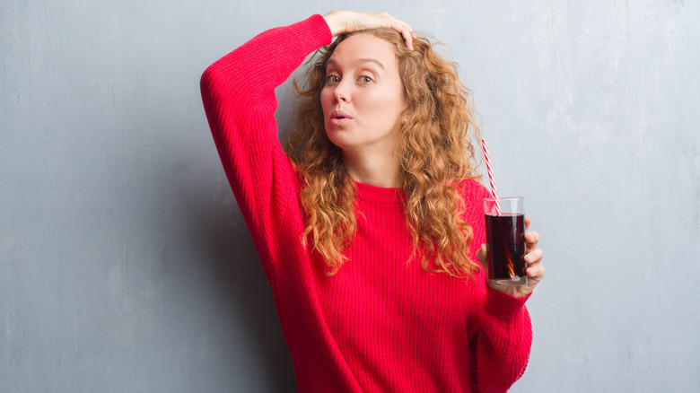 Woman holding glass of soda