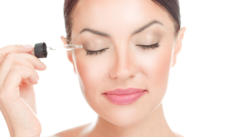 Woman applying eyelash serum