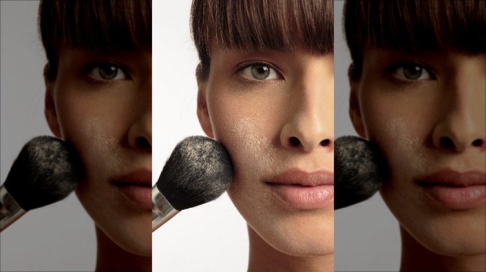Woman with face powder brush