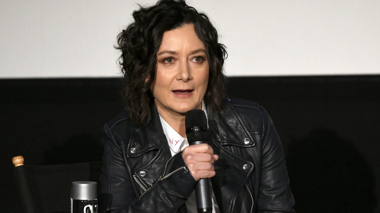 Sara Gilbert holding a microphone