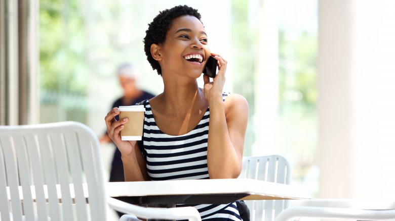 woman talking on the phone with coffee in hand