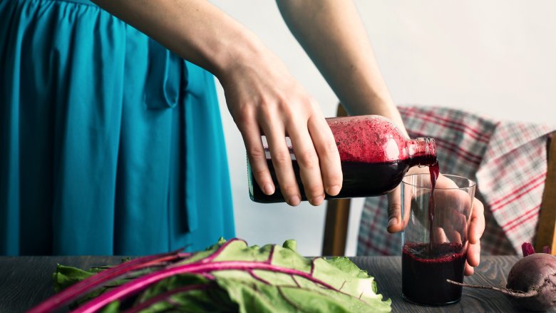 woman pouring a glass of beetroot juice