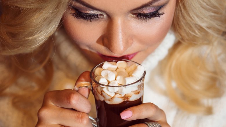 woman holding hot chocolate to mouth