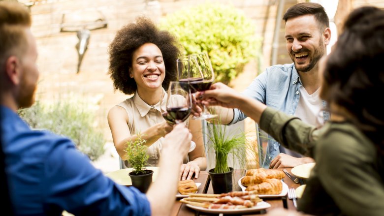 friends clinking glasses of red wine